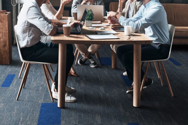 Confident and successful team. Group of young modern people in smart casual wear discussing business while sitting in the creative office